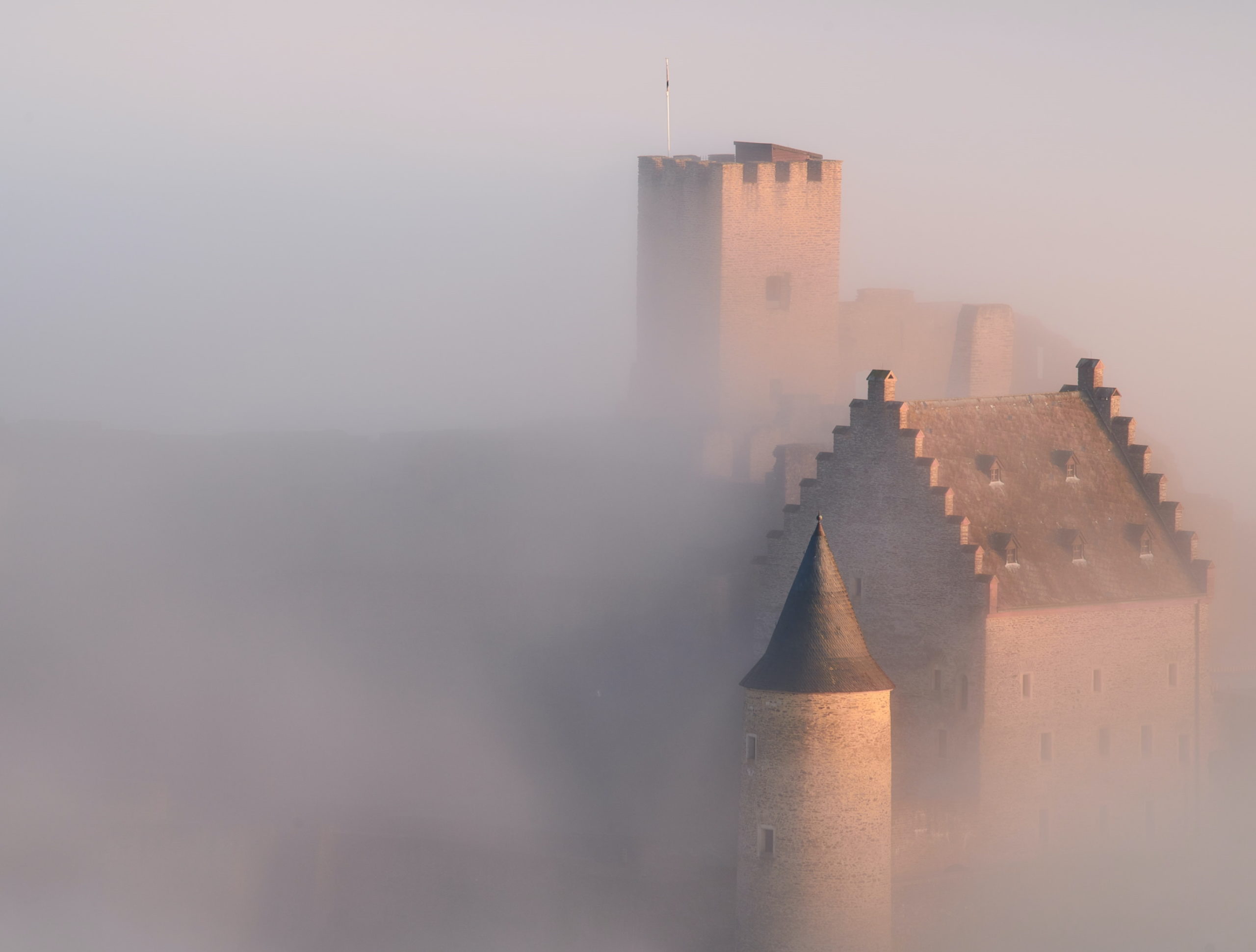 Dekoration: Zu sehen ist eine Burg im Nebel (by Johny Goerend, unsplash.com)